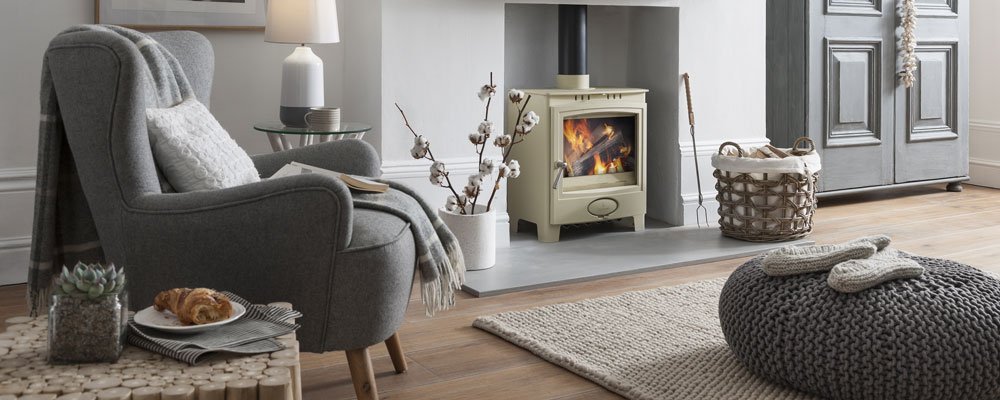 Ecoburn Plus 5 Widescreen stove in Sandcastle cream colour lit in fireplace in modern room